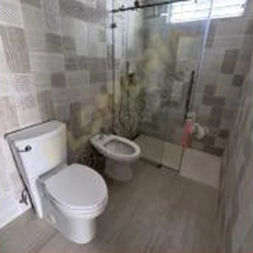 Baño terminado con inodoro instalado y mampara de cristal